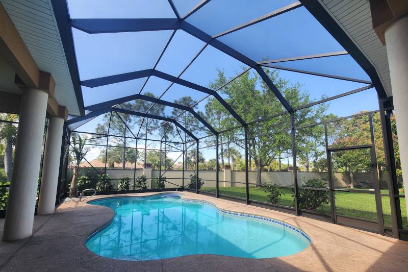 Screened pool enclosure over a backyard pool